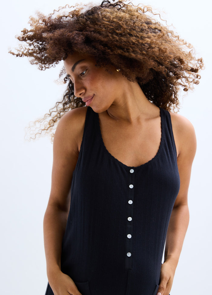 Black ribbed sleeveless maternity jumpsuit with front button detail and scoop neckline.