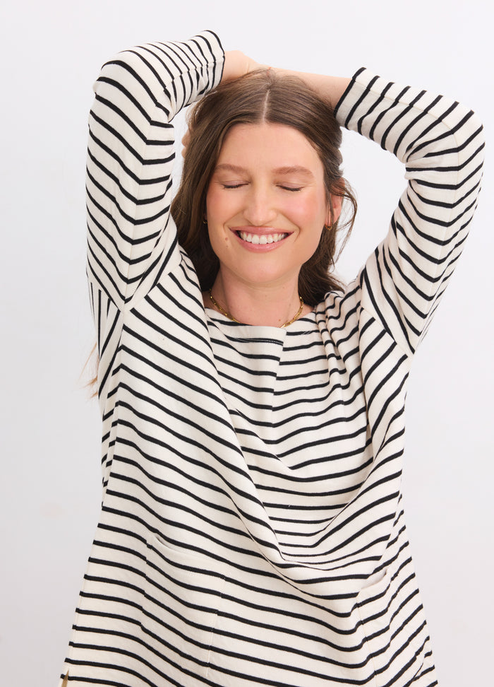 Pregnant woman wearing a black and white striped maternity bateau top with 3/4 sleeves and a relaxed fit.