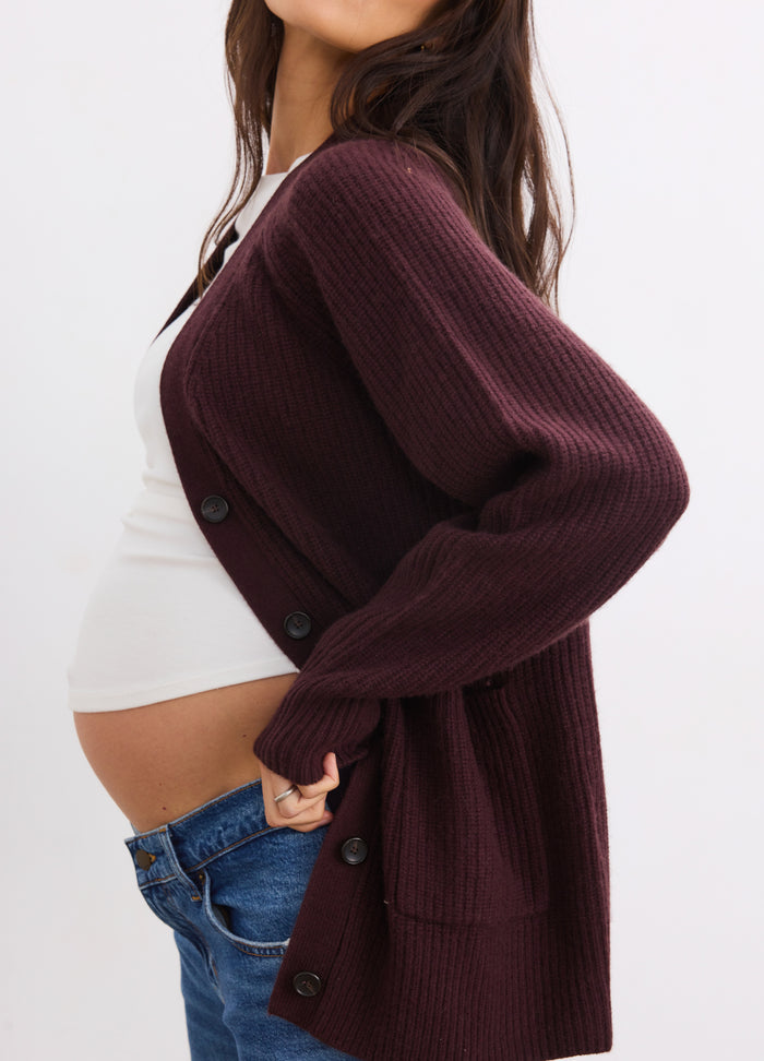 Deep plum cashmere cardigan with buttons, ribbed texture, and relaxed fit for maternity comfort.