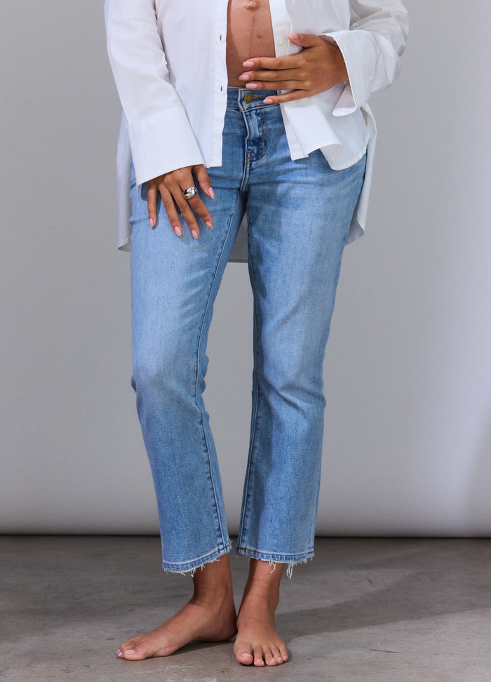 Light wash maternity jeans with cropped straight legs worn by a pregnant model, featuring a soft stretch belly panel.