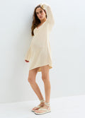 Cream knit maternity mini dress with long sleeves, V-neck, and relaxed fit for pregnant women.