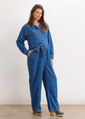 True indigo maternity denim jumpsuit with relaxed fit, button front, and waist tie designed for pregnant comfort.