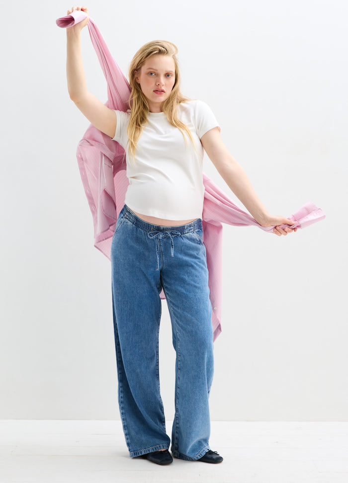 Light blue wide-leg maternity denim pants with a relaxed fit and soft drape.