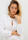 White maternity nursing blouse with long puff sleeves, button details, and keyhole neckline.