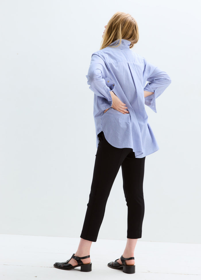 Black slim-fit maternity suit pants with stretch fabric, paired with a loose blue striped shirt and black sandals.