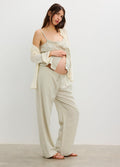 Light beige loose maternity pants with a wide elastic waistband, relaxed fit, worn by a pregnant woman.