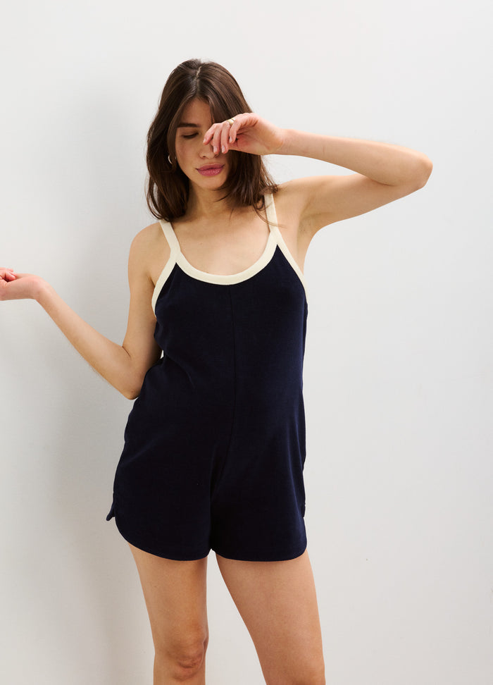 Navy blue maternity romper with cream trim, sleeveless design, and relaxed fit for pregnant women.