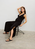 Black wide-leg maternity pants with side slits, worn with a fitted sleeveless black top.