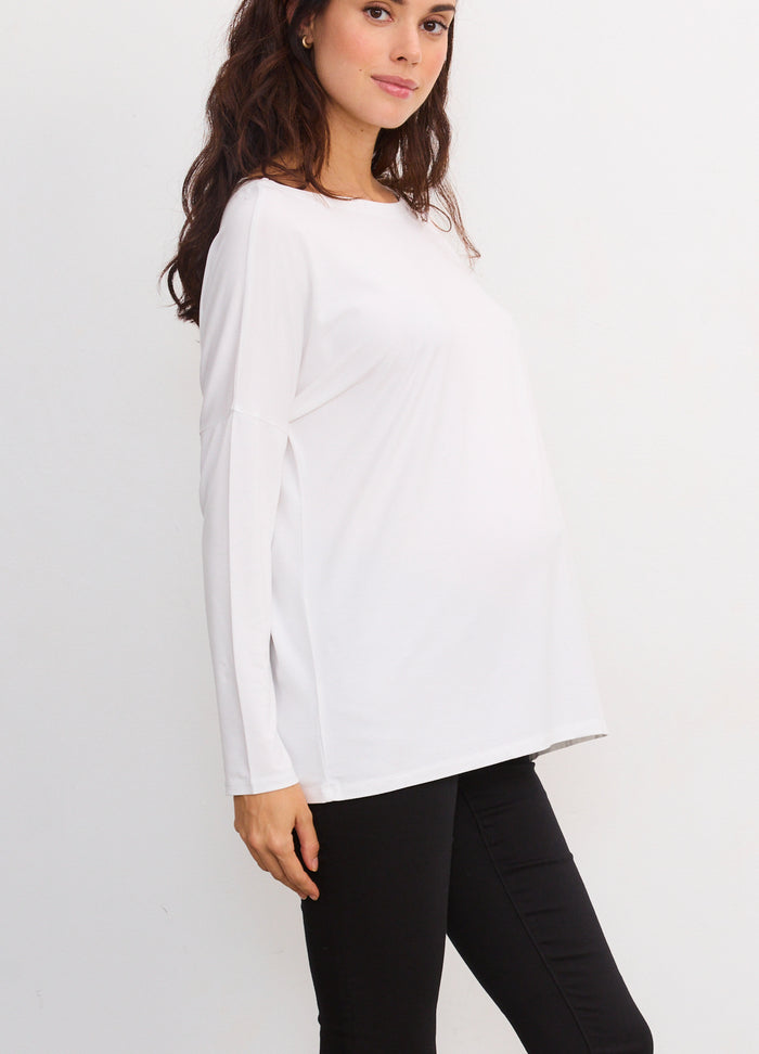 White long-sleeve maternity tee with a relaxed fit, worn by a pregnant model.