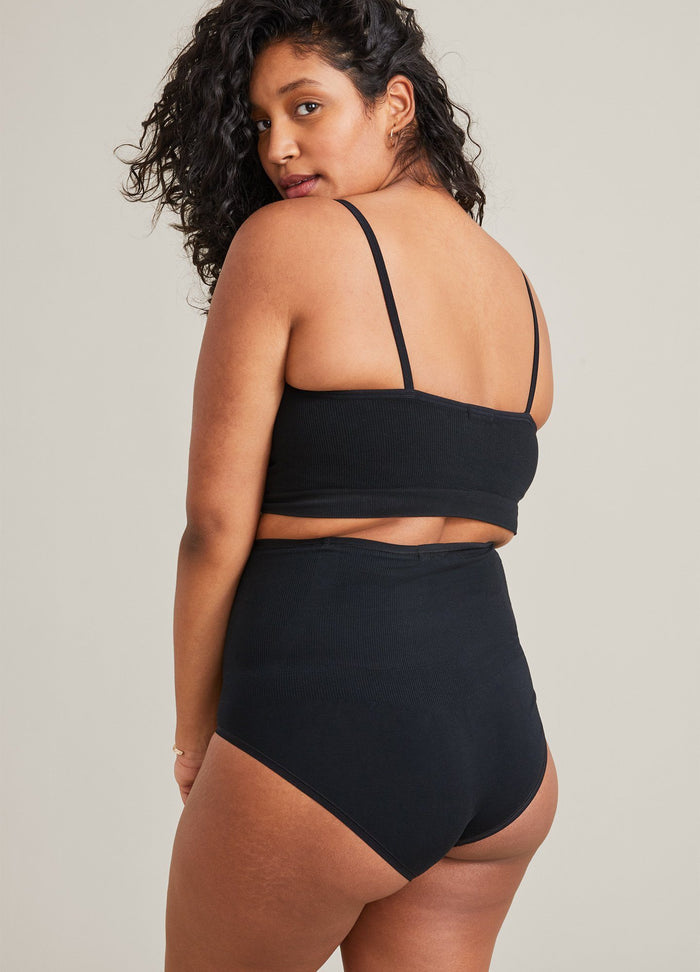 Black seamless maternity bralette with thin adjustable straps paired with high-waisted seamless maternity briefs.