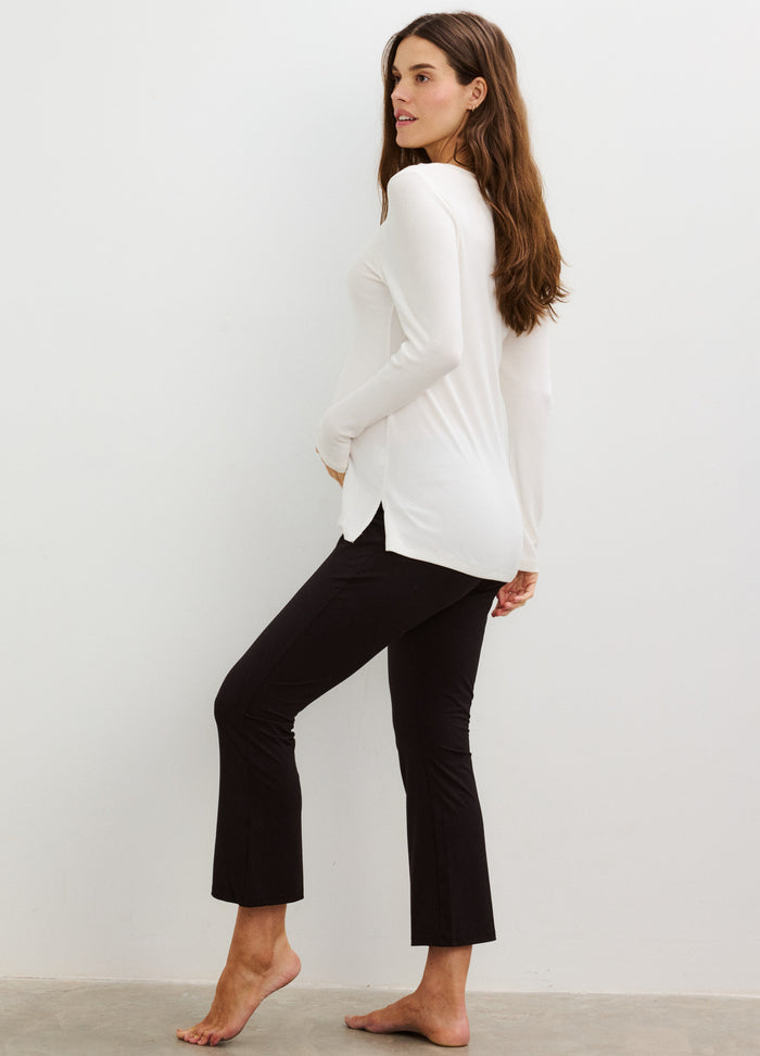 White long-sleeve ribbed nursing henley with side slits paired with black cropped maternity pants.